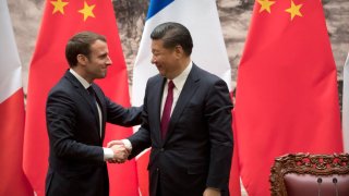 French President Emmanuel Macron (L) and Chinese President Xi Jinping shake hands after a joint press briefing at the Great Hall of the People in Beijing on January 9, 2018.