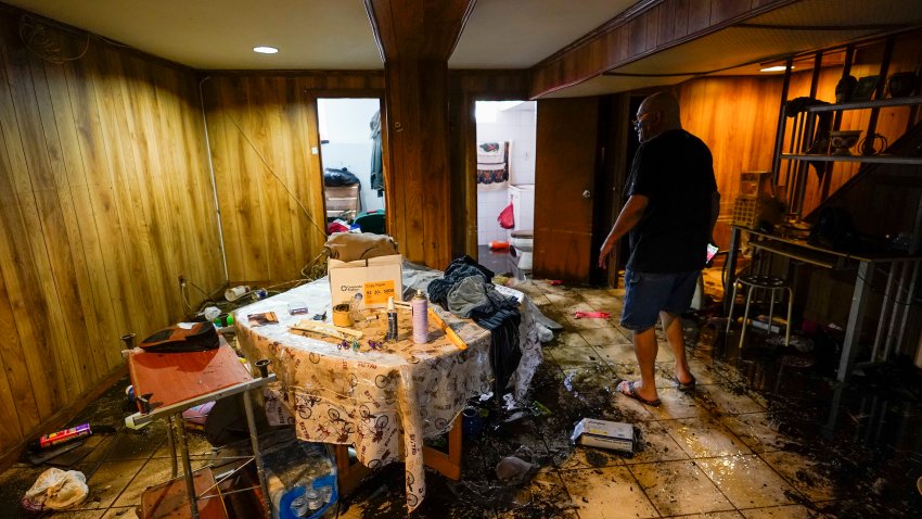 Felix Delapuente, a neighbor of the home in the Queens borough of New York where some of the occupants died including a 2-year old child, shows the flood damage in his basement