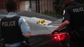 Shell casings labeled 59 and 60 rest on a bullet-riddled car as police investigate the scene of a shooting in the Auburn Gresham neighborhood on July 21, 2020 in Chicago, Illinois.