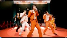 Members of BTS performing on stage.