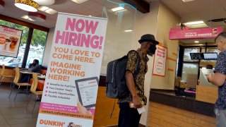 A Now Hiring sign at a Dunkin’ restaurant on September 21, 2021 in Hallandale, Florida.