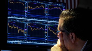 A specialist trader works inside a booth on the floor of the New York Stock Exchange (NYSE) in New York City, October 6, 2021.