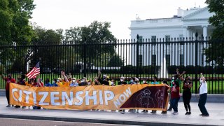 Protesters rally on the sidewalk by the White House