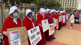 FILE - In this Oct. 22, 2021 file photo, Illinois Handmaids protest abortion restrictions at a rally in downtown Springfield, Ill.