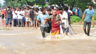 People wade through a flooded street in Nellore, in the southern Indian state of Andhra Pradesh