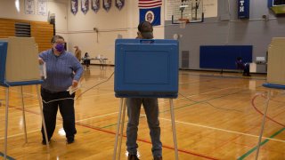 People cast their votes inside of the North Community High School on Tuesday, Nov. 2, 2021 in Minneapolis. Voters in Minneapolis are deciding whether to replace the city's police department with a new Department of Public Safety. The election comes more than a year after George Floyd's death launched a movement to defund or abolish police across the country.