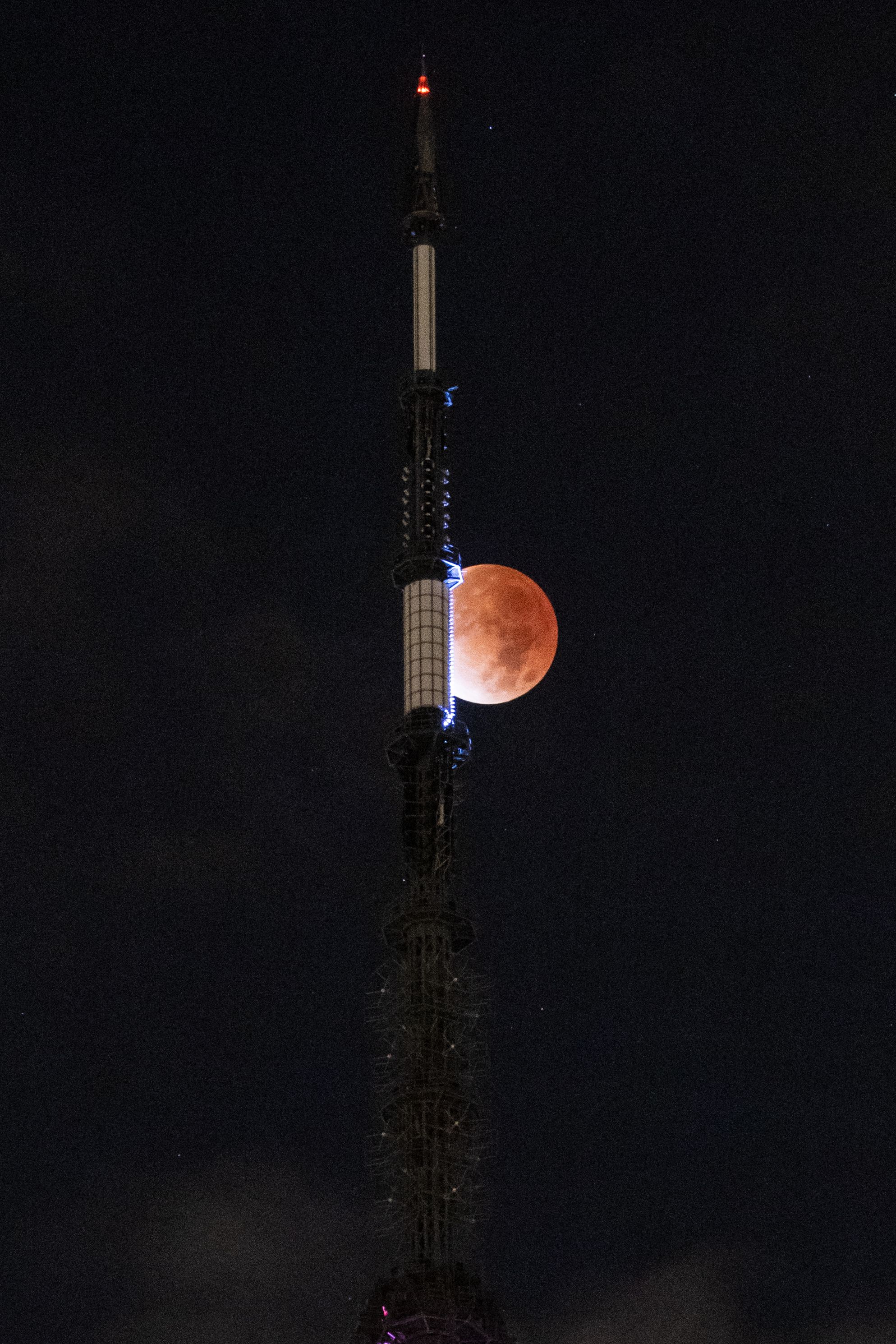 The moon is seen during a lunar eclipse behind the One World Trade Center in New York.