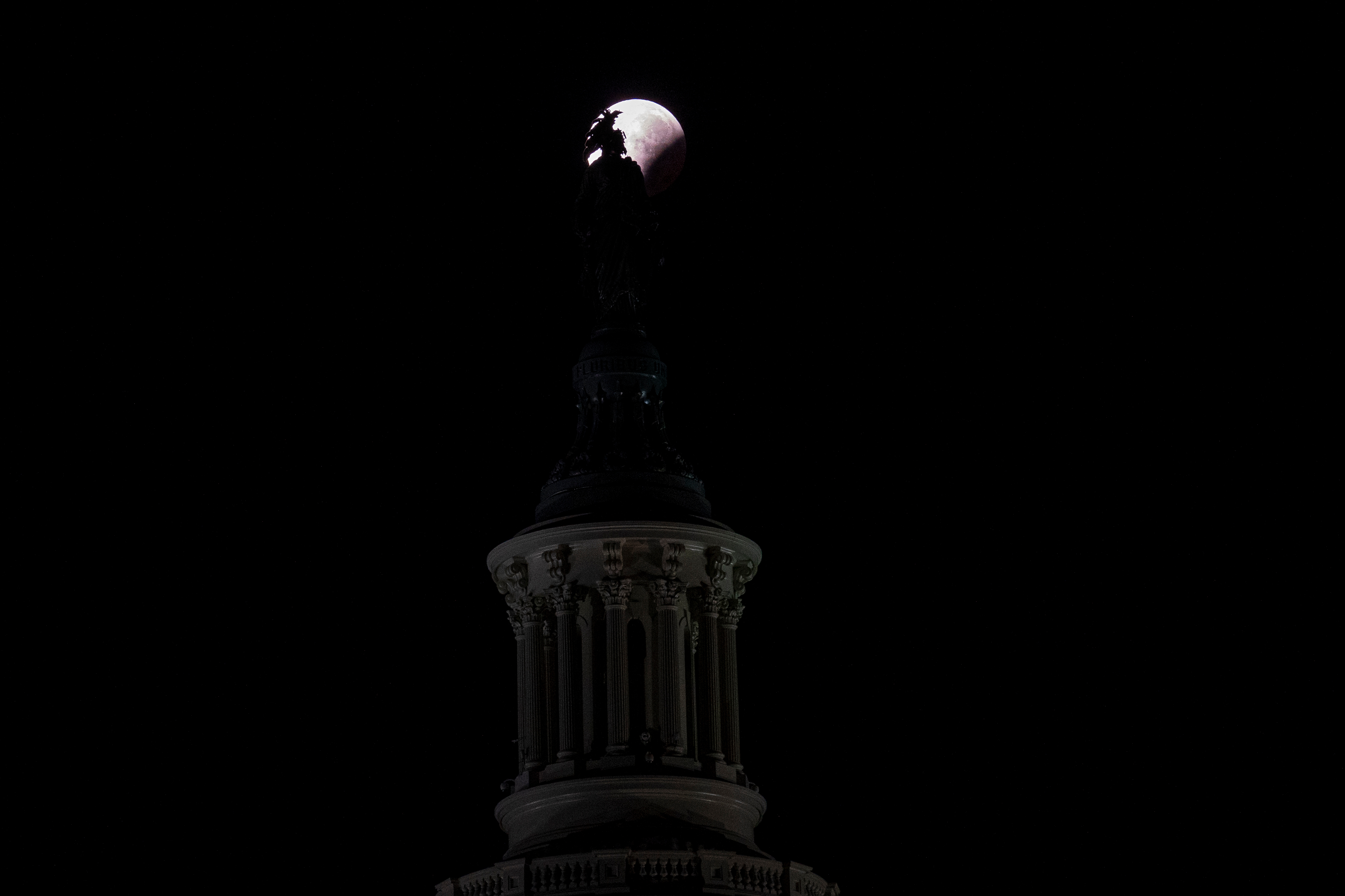 A partial lunar eclipse behind the Statue of Freedom on the U.S. Capitol in Washington, D.C.