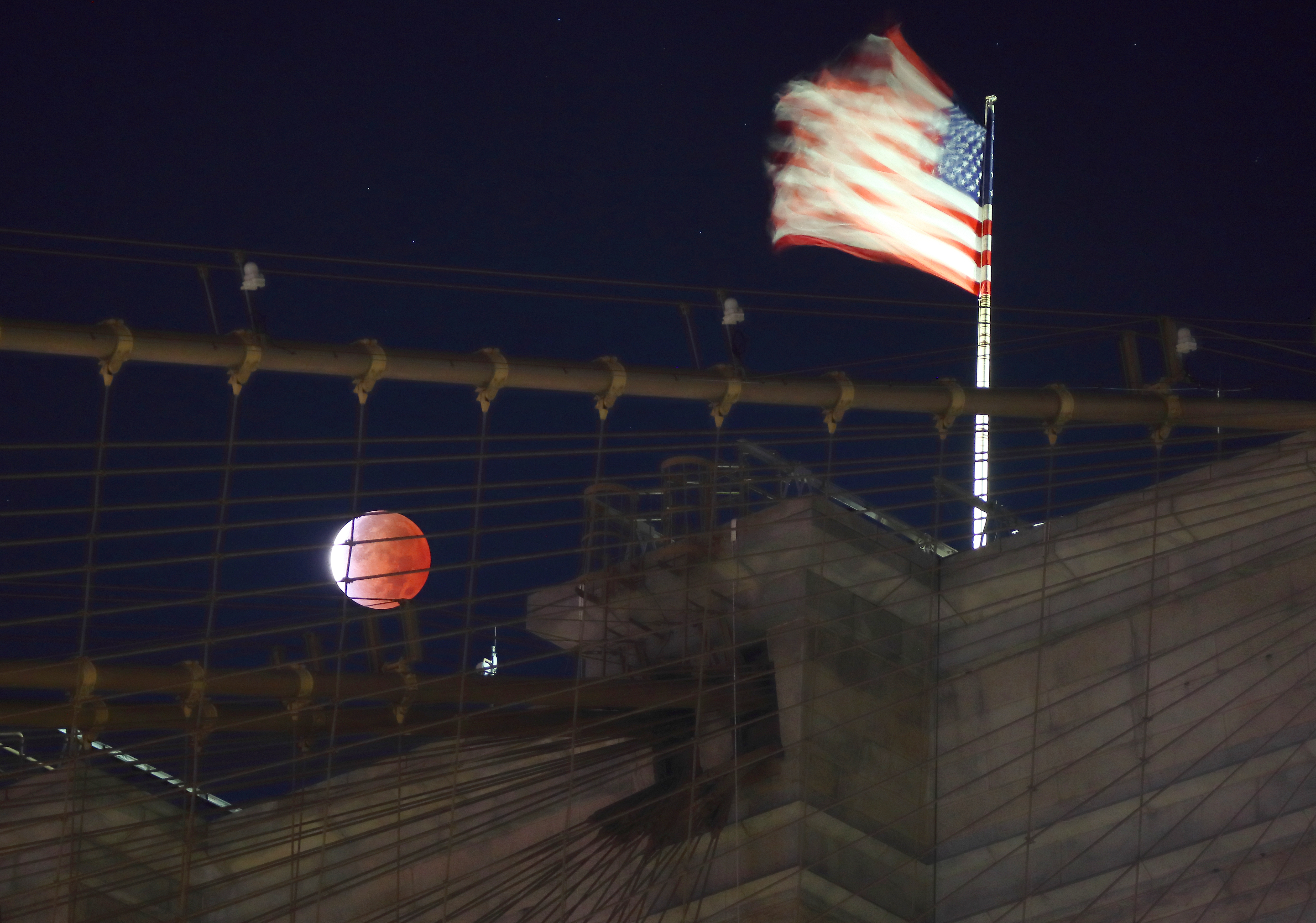 The Beaver Moon turned red during a partial lunar eclipse over the Brooklyn Bridge in New York.