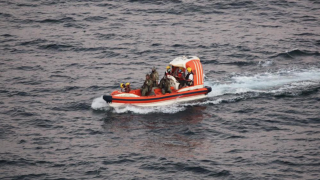 Personnel from a cargo ship help Iranian sailors who had been adrift at sea for eight days.