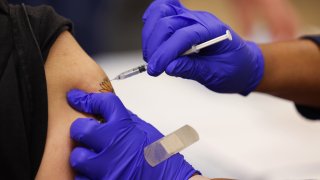 Close-up shot of a Pfizer COVID-19 vaccine booster shot being administered in person’s arm as the Mount Sinai South Nassau Vaxmobile vists Freeport High School, in Freeport, New York on November 30, 2021.