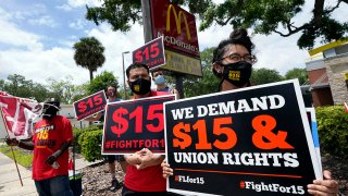 FILE - Workers and family members take part in a 15-city walkout to demand $15/hr wages, May 19, 2021, in front of a McDonald's restaurant in Sanford, Fla.