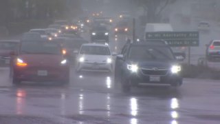 Cars drive in the rain in San Diego.