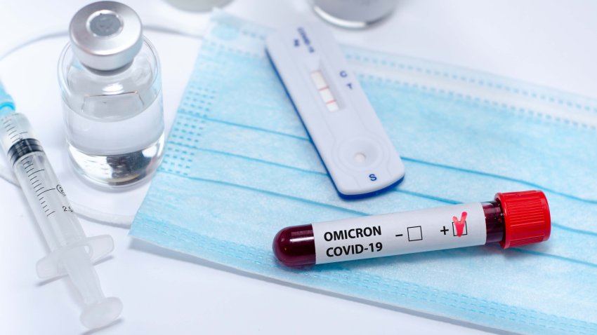 Test tube with positive  Omicron COVID-19 test blood sample and positive COVID-19 rapid test in the medical laboratory.