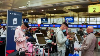 Passengers line up at John F. Kennedy International Airport after airlines announced numerous flights were canceled during the spread of the Omicron coronavirus variant on Christmas Eve in Queens, New York, December 24, 2021.