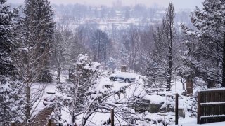 In this photo, snow covers the burnt remains of homes after the Marshall Wildfire Saturday, Jan.1, 2022, in Louisville, Colo.