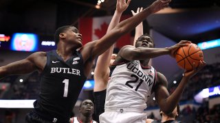 Connecticut's Adama Sanogo (21) shoots as Butler's Bo Hodges (1) defends during the first half of an NCAA college basketball game Tuesday, Jan. 18, 2022, in Hartford, Connecticut.