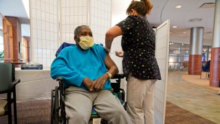 FILE – Edward Williams, 62, a resident at the Hebrew Home at Riverdale, receives a COVID-19 booster shot in New York Sept. 27, 2021.