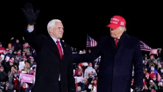 President Donald Trump and Vice President Mike Pence gesture after a campaign rally at Gerald R. Ford International Airport, early Tuesday, Nov. 3, 2020, in Grand Rapids, Mich.