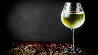 Glass of chilled white wine on wooden background