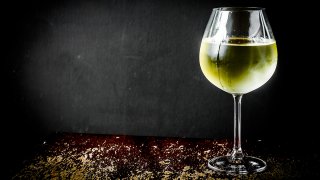 Glass of chilled white wine on wooden background