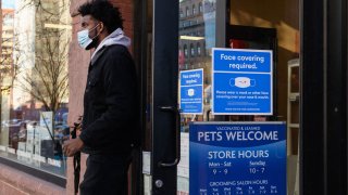 A person wearing a face mask leaves a store on January 26, 2022 in New York City.