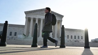 A person walks down the sidewalk near the U.S. Supreme Court building in Washington, D.C., February 16, 2022.