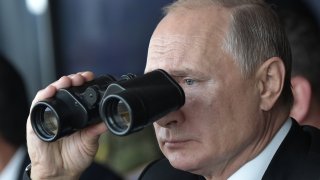 Russian President Vladimir Putin watches with binoculars the Tsentr-2019 military exercise at the Donguz range near Orenburg city on September 20, 2019.