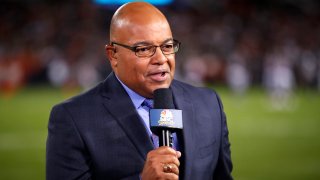FILE - In this Sept. 5, 2019, file photo, NBC sportscaster Mike Tirico works the sidelines during an NFL football game between the Green Bay Packers and the Chicago Bears in Chicago. Tirico is about to give new meaning to double duty when NBC broadcasts the Olympics and Super Bowl next month. Tirico will anchor the network’s primetime coverage of the Beijing Games, but will also host the Super Bowl pregame show from Los Angeles on Feb. 13 2022.