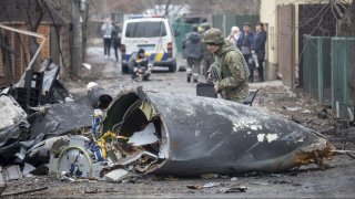 A Ukrainian Army soldier inspects fragments of a downed aircraft in Kyiv, Ukraine, Feb. 25, 2022.