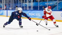 Brock Faber of Team USA and Wei Zhong of Team China battle for the puck at the men's ice hockey preliminary round match during the 2022 Winter Olympics in the National Indoor Stadium, Feb. 10, 2022, in Beijing, China.