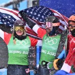 USA's Nick Baumgartner (2nd L) holds his national flag with USA's Lindsey Jacobellis (L) after winning the snowboard mixed team cross big final during the 2022 Winter Olympics at the Genting Snow Park P & X Stadium in Zhangjiakou, China on Feb. 12, 2022.