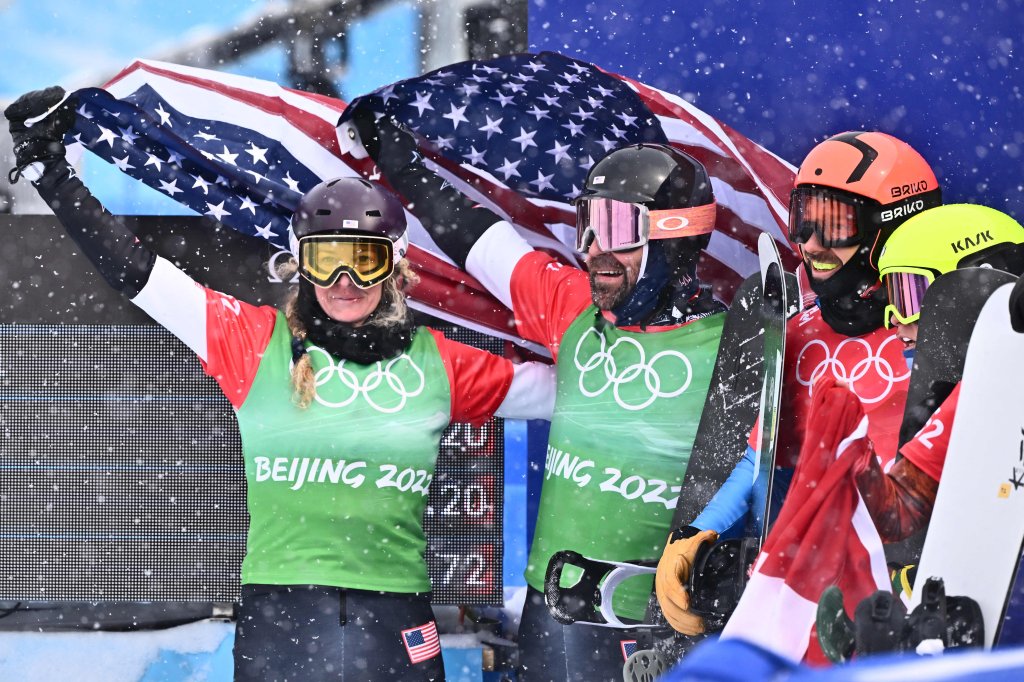 USA's Nick Baumgartner (2nd L) holds his national flag with USA's Lindsey Jacobellis (L) after winning the snowboard mixed team cross big final during the 2022 Winter Olympics at the Genting Snow Park P & X Stadium in Zhangjiakou, China on Feb. 12, 2022.