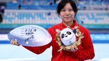 Gold medallist Miho Takagi of Team Japan poses with a board showing her new Olympic record time of 1:13.19 for the Women's 1000m speed skating competition at the 2022 Winter Olympics, Feb. 17, 2022, in Beijing.