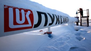 A worker checks the valve of an oil pipe at the Lukoil company owned Imilorskoye oil field outside the West Siberian city of Kogalym, Russia.
