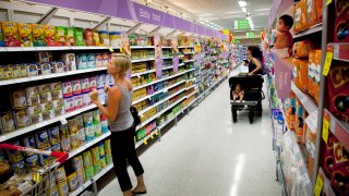 A woman shops for baby food in a grocery store.
