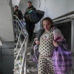 An injured pregnant woman walks downstairs in the damaged by shelling maternity hospital in Mariupol, Ukraine, Wednesday, March 9, 2022. A Russian attack has severely damaged a maternity hospital in the besieged port city of Mariupol, Ukrainian officials say.