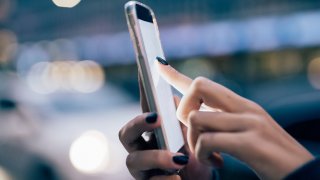 Close up on the hand of young woman using a smartphone