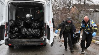 EDITORS NOTE: Graphic content / Communal workers carry a body of a civilian man killed by Russian troops shelling in town of Bucha, not far from the Ukrainian capital of Kyiv on April 3, 2022.