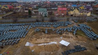 Plastic bags with corpses exhumed from a mass grave are lined up in Bucha, on the outskirts of Kyiv, Ukraine, Friday, April 8, 2022.