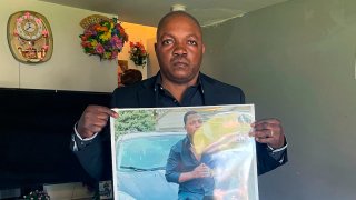 Peter Lyoya holds up a picture of his son Patrick Lyoya,