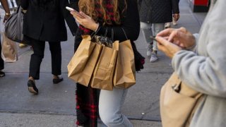 A pedestrian carries shopping bags in the Herald Square area of New York, U.S., on Wednesday, April 13, 2022.