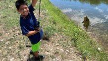 Jose Flores holding a fishing rod with a fish on the line.