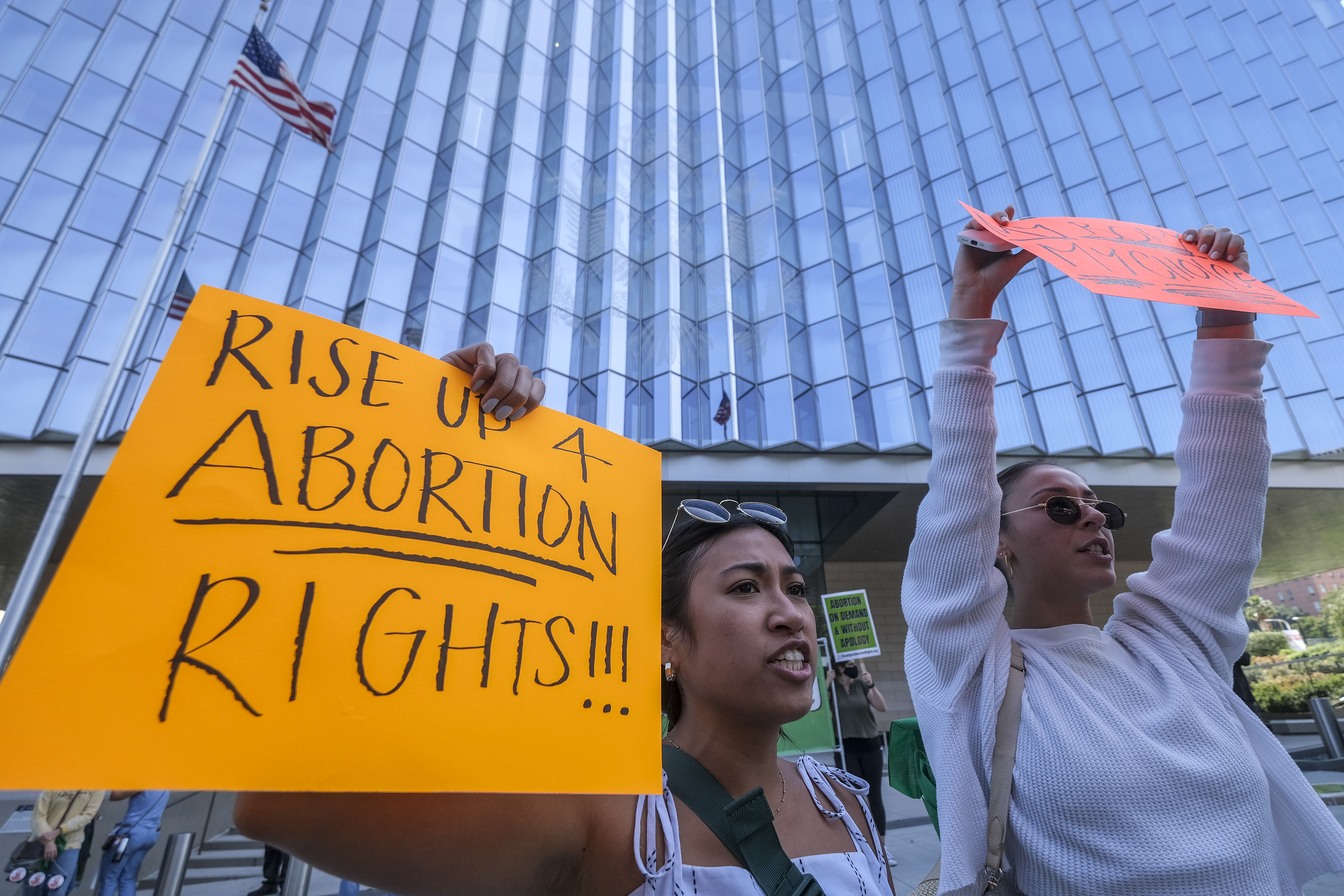 Demonstrators holding signs protest outside of the U.S. Courthouse in response to a leaked draft of the Supreme Court’s opinion to overturn Roe v. Wade, in Los Angeles, Tuesday, March 3, 2022.