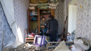 Women collect belongings in their apartment destroyed by Russian airstrike in Bakhmut, Donetsk region, Ukraine, Saturday, May 7, 2022.