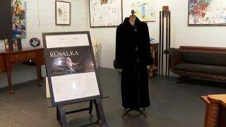 FILE - In this image from video, a black mink fur coat, right, and a signed opera poster belonging to the late Justice Ruth Bader Ginsburg, are seen inside Potomack Company Auctions in Alexandria, Va., Monday, April 11, 2022. An online auction of 150 of items owned by Ginsburg raised $803,650 for Washington National Opera. The opera was one of the late justice’s passions.