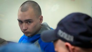 Russian army Sergeant Vadim Shishimarin, 21, is seen behind a glass during a court hearing in Kyiv, Ukraine, Wednesday, May 18, 2022. The Russian soldier has gone on trial in Ukraine for the killing of an unarmed civilian. The case that opened in Kyiv marked the first time a member of the Russian military has been prosecuted for a war crime since Russia invaded Ukraine 11 weeks ago.