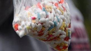 A bag of assorted pills and prescription drugs dropped off for disposal is displayed during the Drug Enforcement Administration (DEA) 20th National Prescription Drug Take Back Day at Watts Healthcare on April 24, 2021.