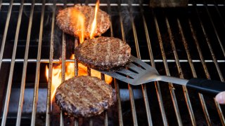Burgers cooking on barbecue grill.