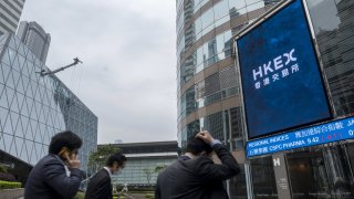 Pedestrians walk past the Exchange Square complex, which houses the Hong Kong Stock Exchange, in Hong Kong, China, on Tuesday, March 23, 2021.